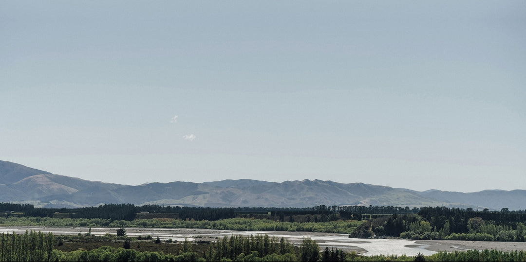 Scenic view of a river with mountains in the background under a clear sky.